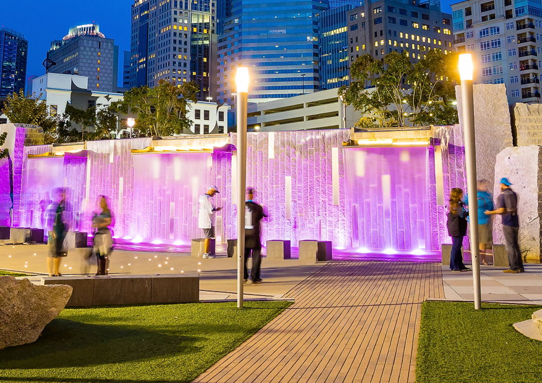 Image of a park in Charlotte, NC with a purple wall lit up at night